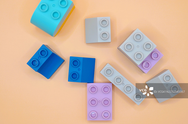 多彩的玩具积木在桃色背景上排列图片素材
