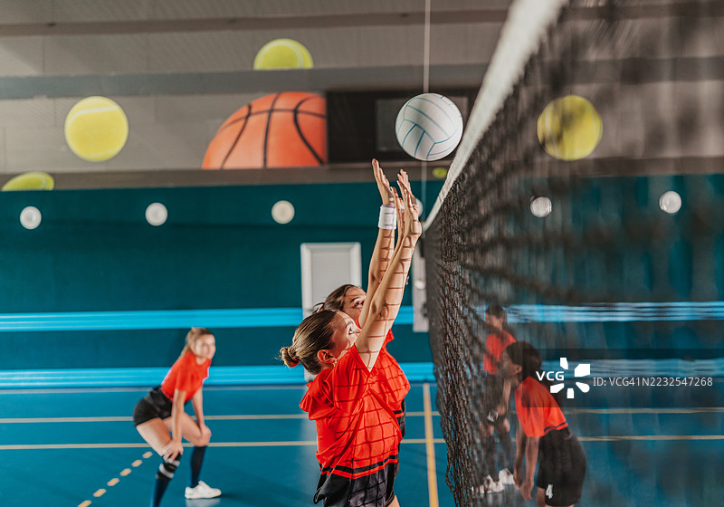年轻女性进行室内排球竞赛，展现团队合作与运动能力图片素材