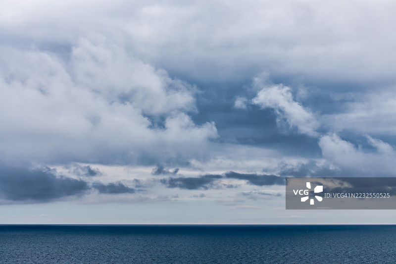 丹麦平静海面上方的戏剧性多云天空图片素材