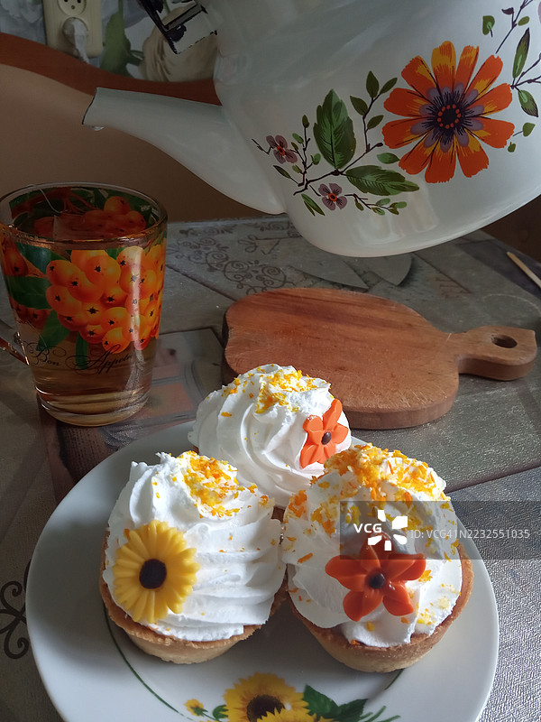 装饰精美的杯子蛋糕，上面有花卉图案，摆放在桌子上图片素材