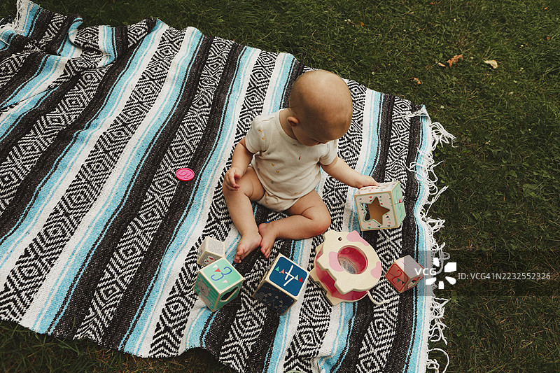 婴儿在毯子上玩玩具图片素材