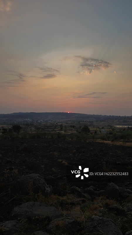 乡村风景的日落，起伏的山丘和遥远的地平线图片素材