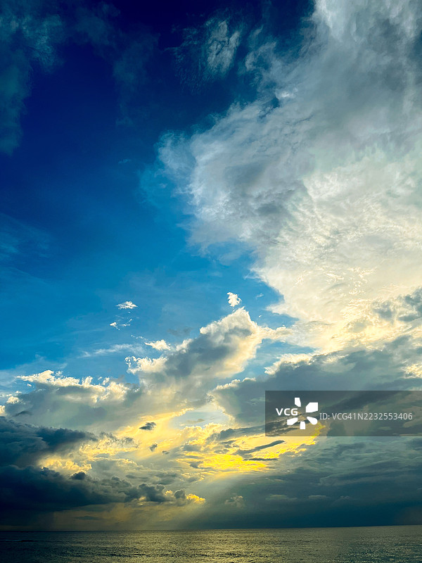 海洋上方的戏剧性日落与绚丽的云彩图片素材