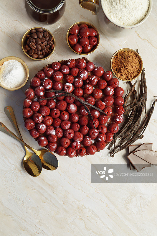 高角度视图的樱桃挞与大理石桌上的烘焙材料图片素材