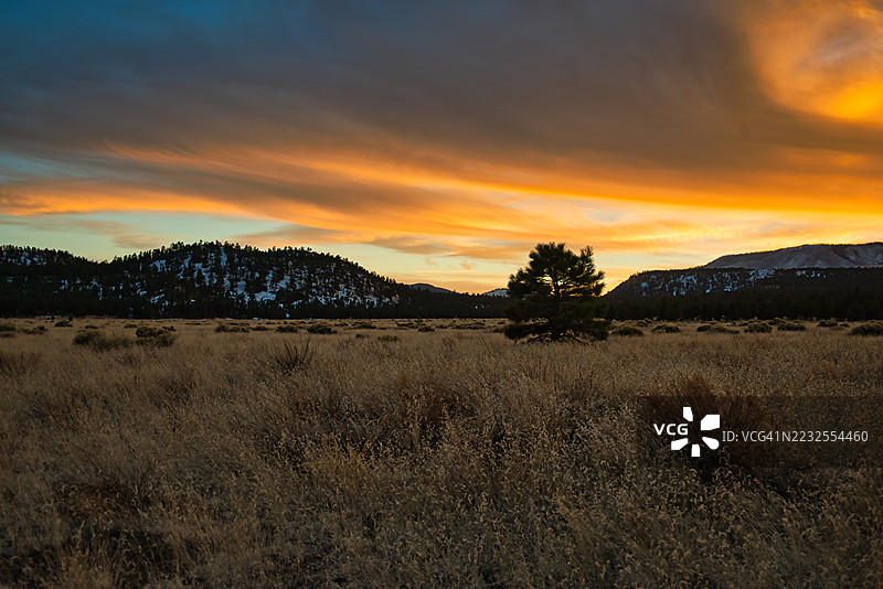 远山环绕的宁静田野上空壮丽的日落，美国，弗拉格斯塔夫图片素材