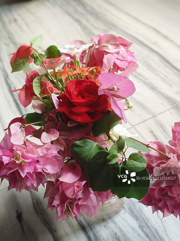 鲜艳的玫瑰和九重葛花束放在大理石表面上图片素材