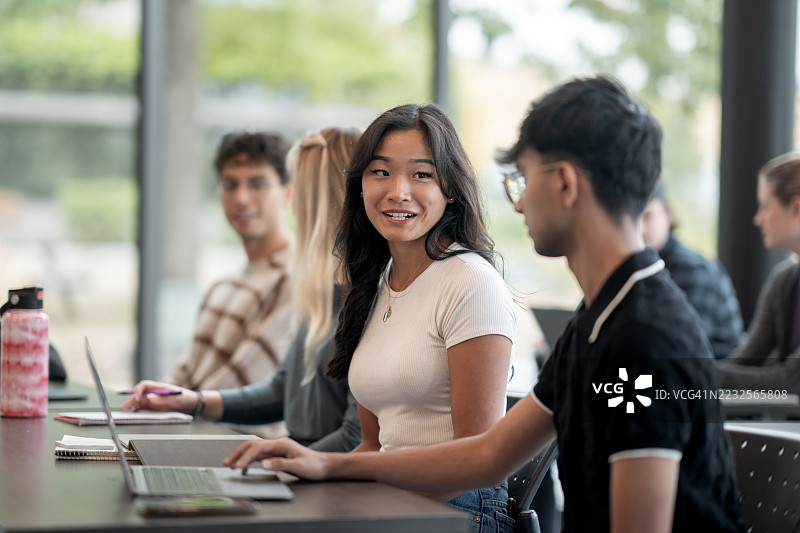 多元化学生在现代教室环境中热情互动图片素材