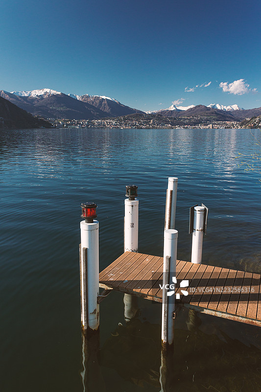 宁静的湖泊景观，雪山环绕，木栈道，意大利图片素材