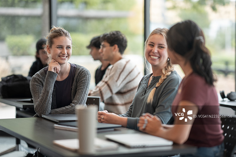 一群年轻人在现代教室中享受交谈与团队合作图片素材