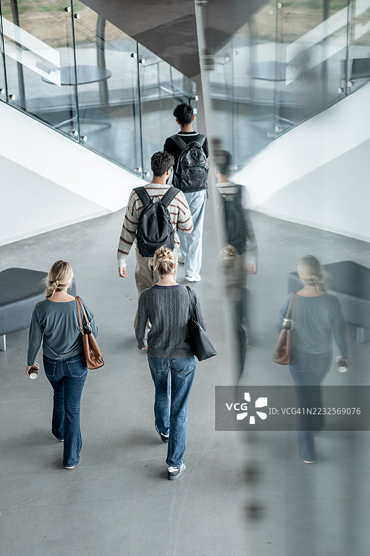 一群学生在现代教育建筑中一起走路图片素材