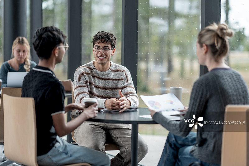 一群人在明亮休闲的咖啡店环境中合作图片素材