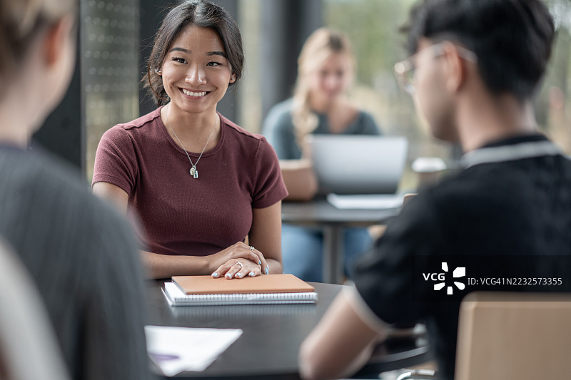 微笑的年轻女性在咖啡馆参加小组学习会图片素材