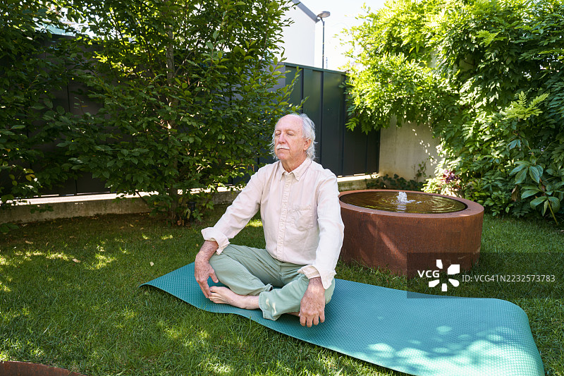 年长的西班牙裔男性在家中花园冥想图片素材