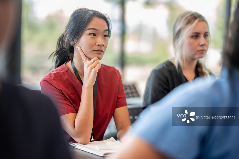 穿着红色制服的细心护理学生在课堂上上课图片素材