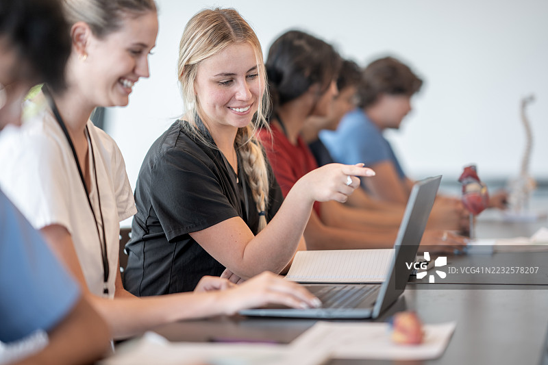 医学生在教室环境中合作使用笔记本电脑图片素材