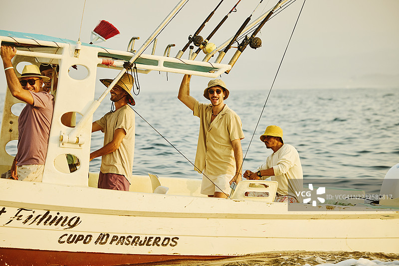 父亲和成年儿子们在度假期间享受钓鱼之旅的广角镜头图片素材