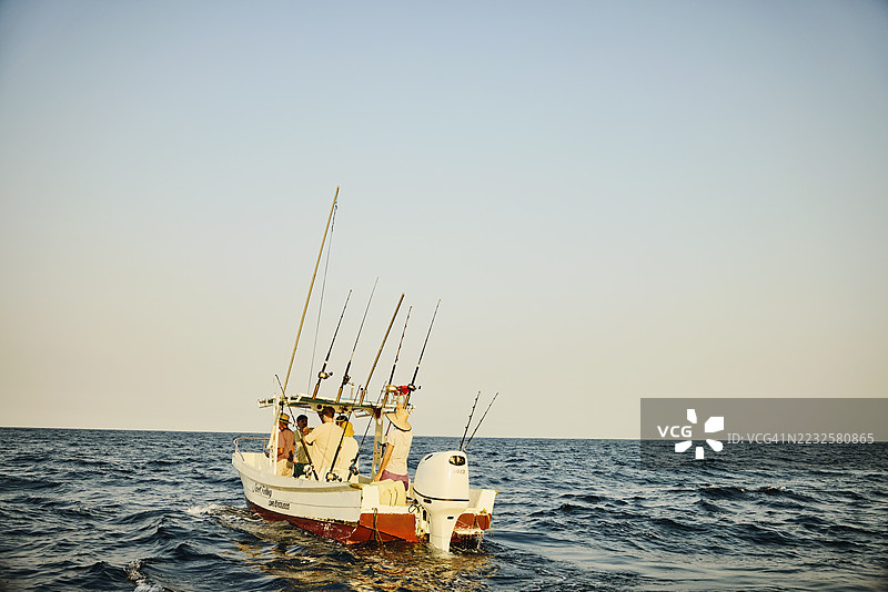 在太平洋上，朋友们在包租的钓鱼船上享受宽广的拍摄镜头图片素材