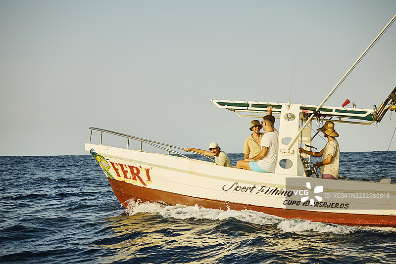 男性朋友们在钓鱼船上放松的广角镜头图片素材