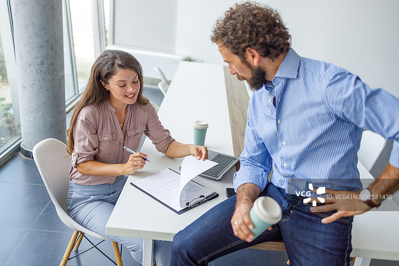 商务人士在办公室会议中讨论合同条款图片素材