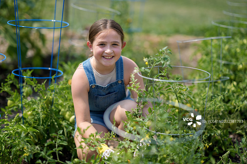年轻女孩在绿色户外空间享受阳光明媚的园艺时光图片素材