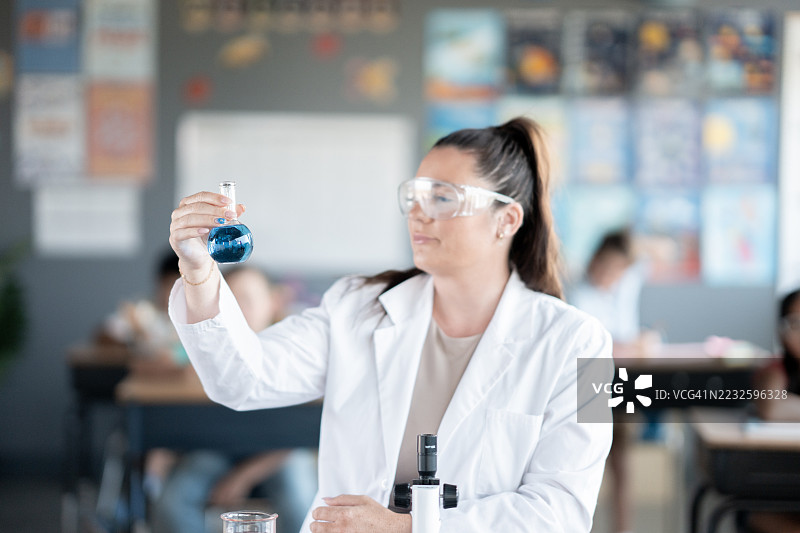 女性科学家在教室实验室环境中分析液体图片素材