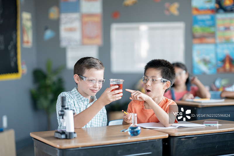 孩子们在教室里用显微镜和安全眼镜进行科学实验图片素材