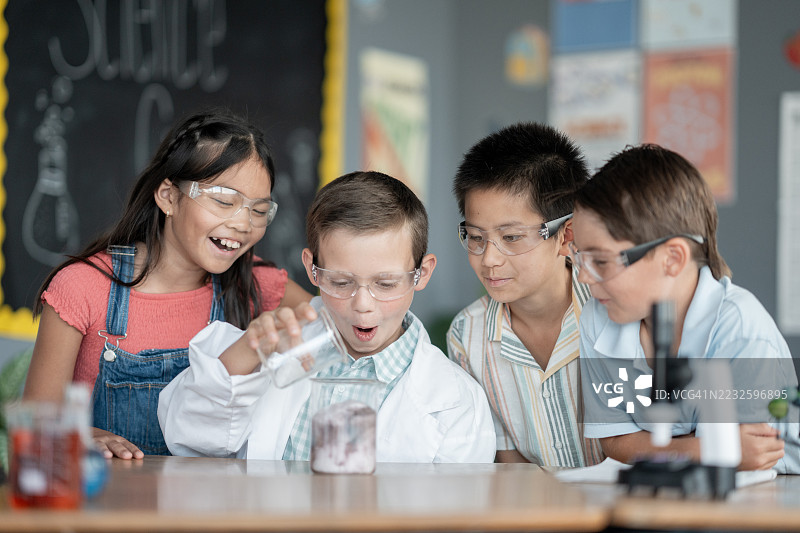 孩子们在教室里进行科学实验，佩戴安全护目镜图片素材