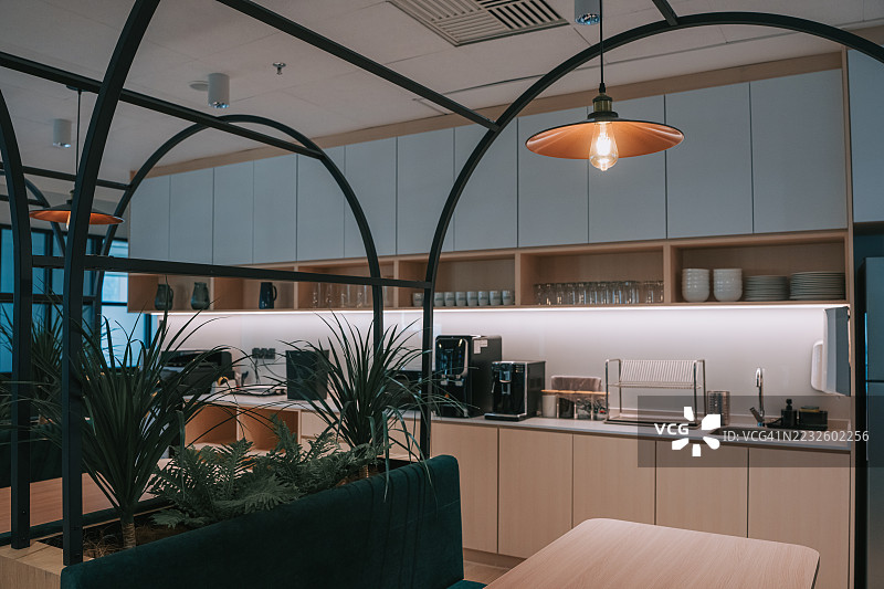 现代共享办公空间的茶水间，配有咖啡机和用餐区。图片素材