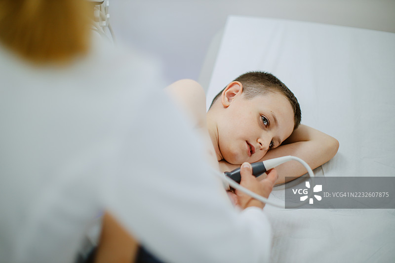 医生为一名年轻男孩患者进行超声检查图片素材