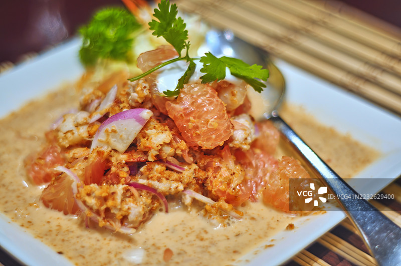 一盘色彩鲜艳、艺术感十足的沙拉，盛放在方形白色盘子里。图片素材