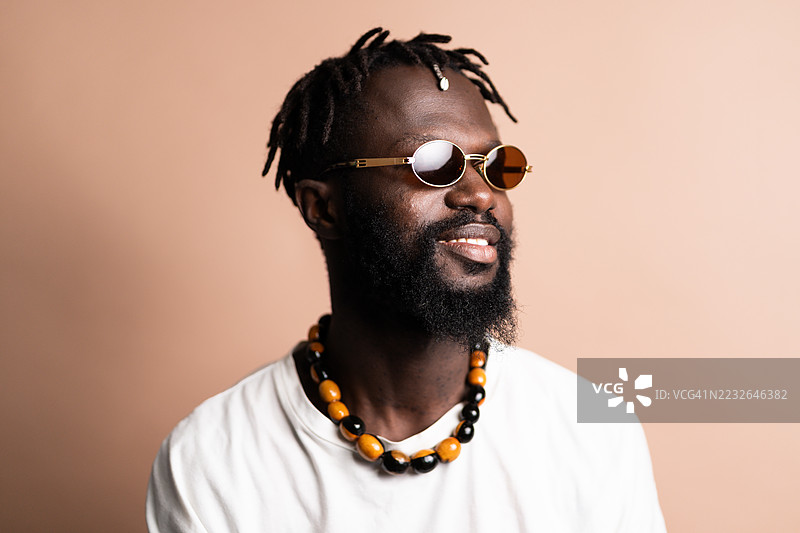 时尚的非洲裔美国音乐家佩戴着太阳镜和木质项链图片素材