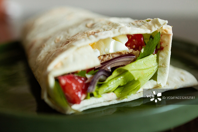 近距离拍摄的拉瓦什卷饼，内含金枪鱼、鸡蛋和新鲜蔬菜图片素材
