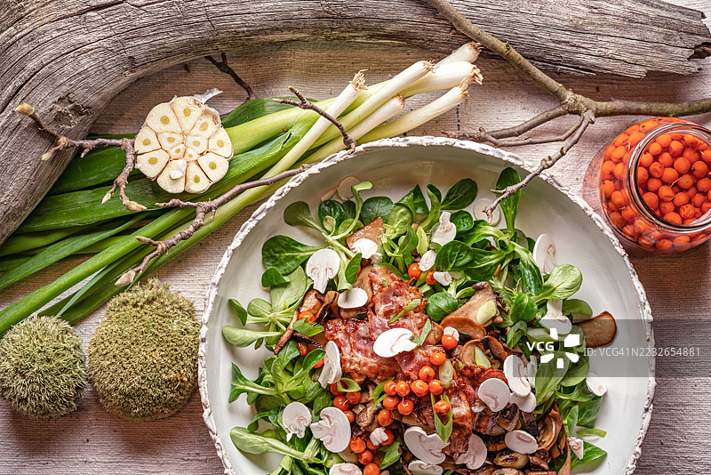 各种新鲜蘑菇配春葱和大蒜，搭配脆皮培根和羊生菜。图片素材