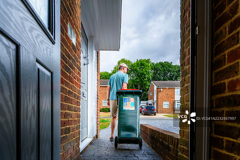 中年男性房主正在拿出回收箱图片素材