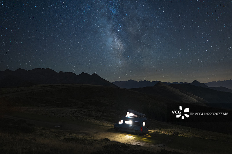 一辆露营车在高山上星空下野营图片素材