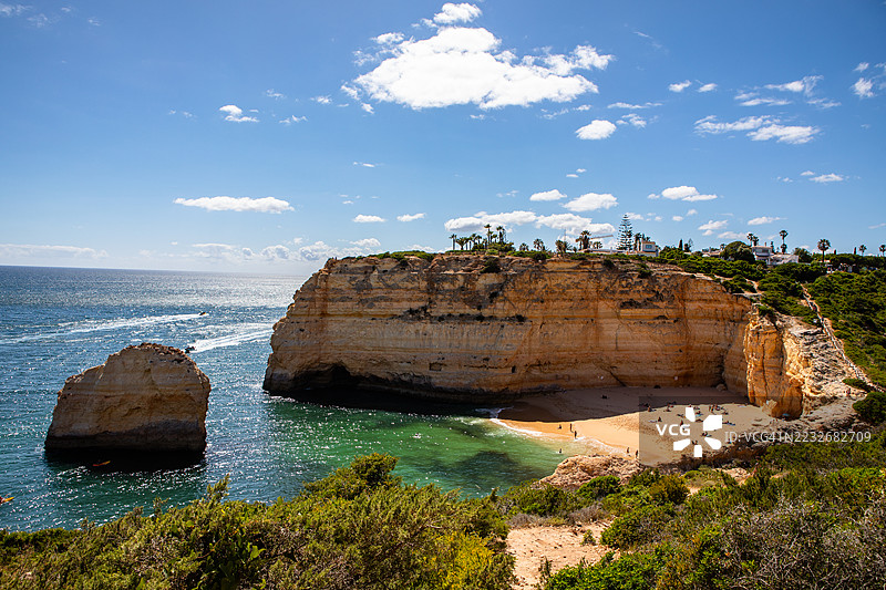 隐秘的金色沙滩鸟瞰图，清澈的海洋被高耸的悬崖环绕，位于葡萄牙卡尔沃埃罗的卡尔瓦略海滩。图片素材