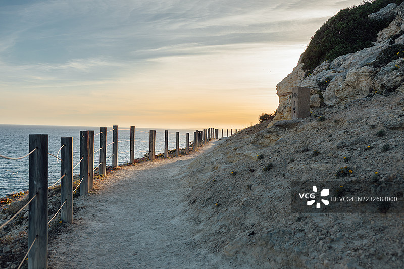 葡萄牙卡尔沃埃罗的海岸悬崖步道在日落时分的海岸景观。图片素材