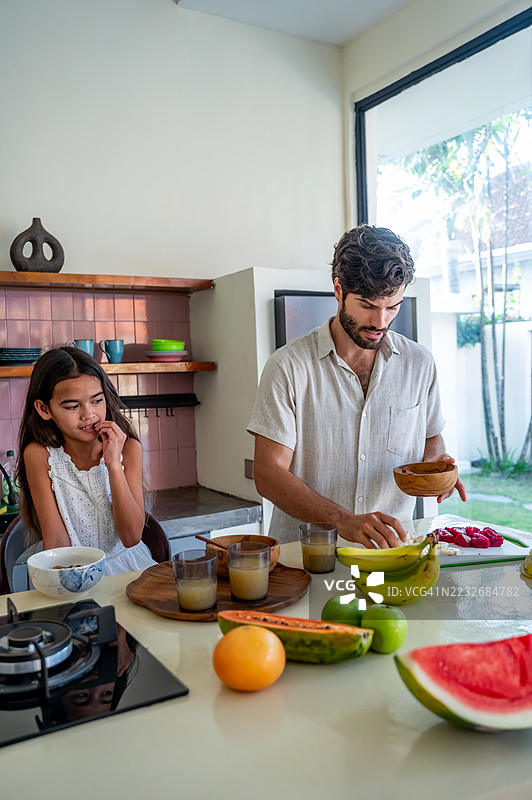 父亲和女儿在现代厨房一起准备新鲜水果图片素材