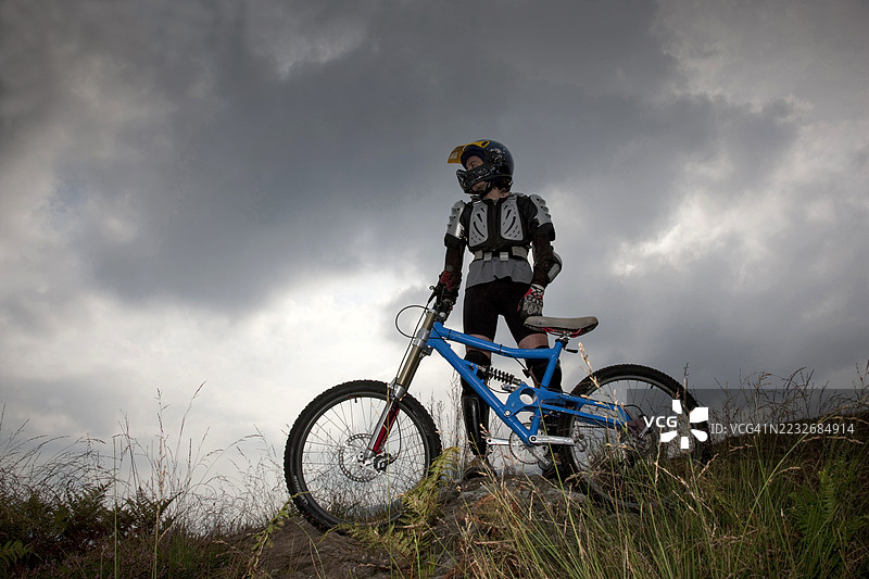 在阴云密布的天空下，穿着保护装备的骑士。图片素材