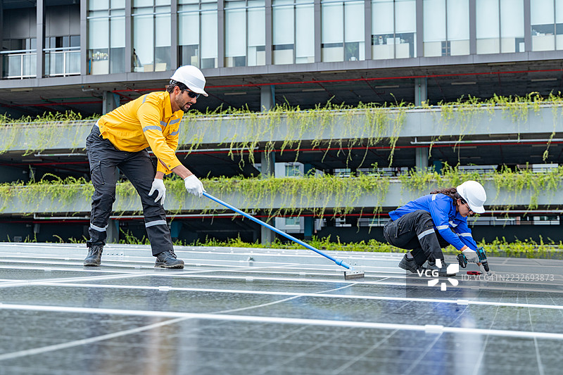 技术人员清洁和检查屋顶太阳能电池板图片素材
