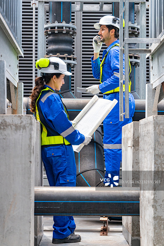 工程师在工业管道附近分析蓝图图片素材