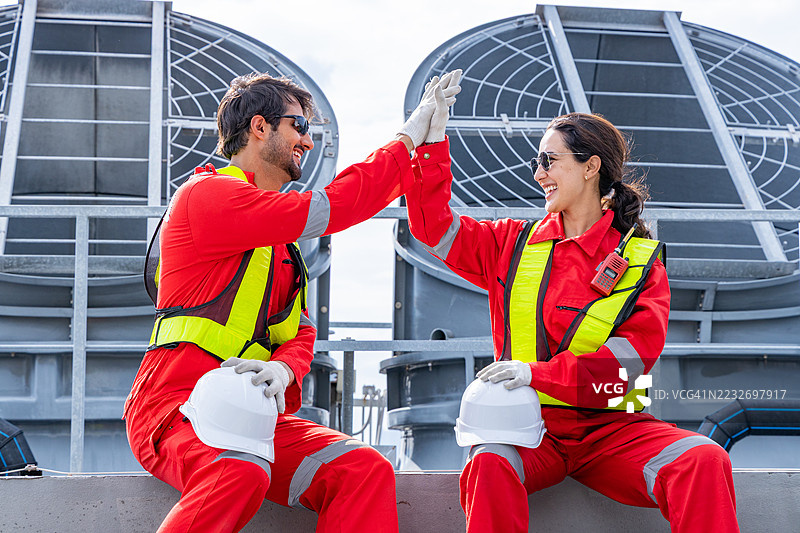 工程师们在屋顶庆祝团队合作的成功图片素材