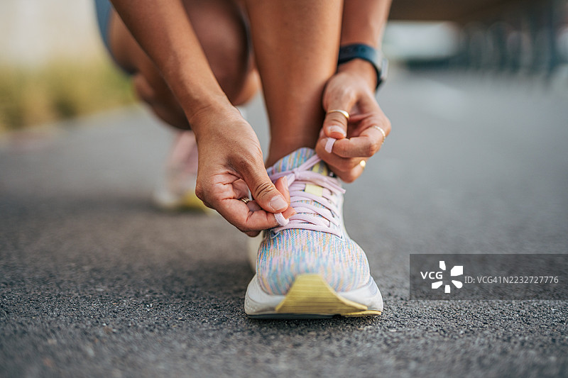 年轻的运动女性在锻炼前系跑鞋图片素材