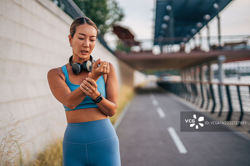 年轻女运动员在户外跑步后感到手腕疼痛图片素材