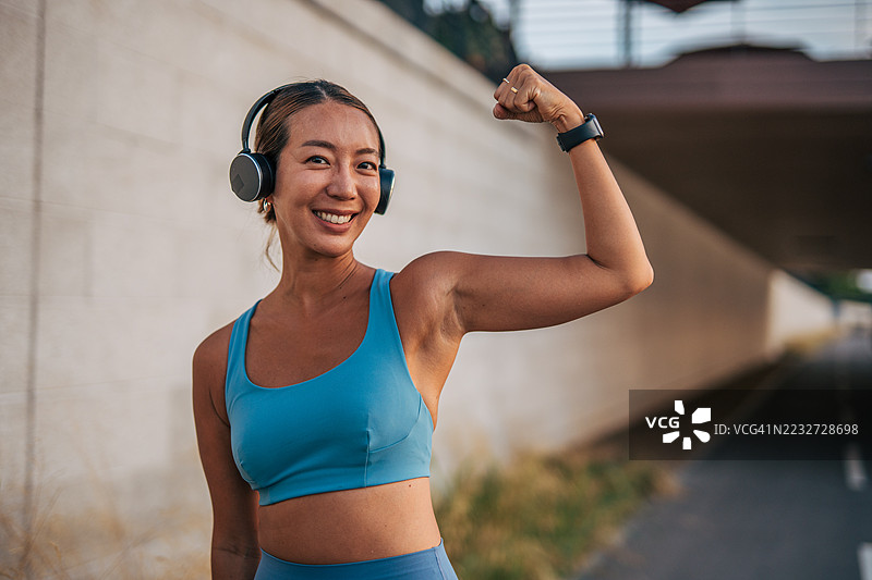 年轻的运动女性在训练后展示她的二头肌图片素材