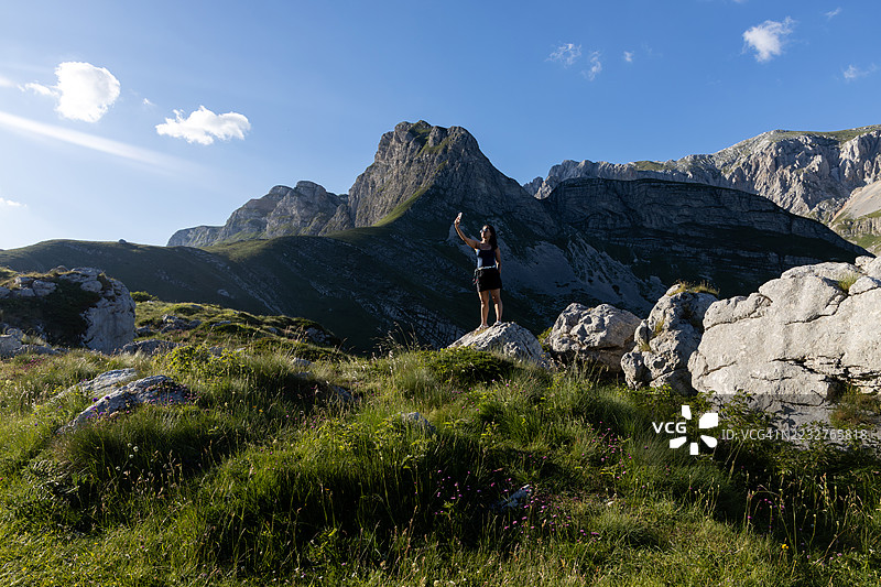 年轻游客在黑山杜米托尔国家公园扎布利亚克市的塞德洛山口用智能手机自拍图片素材