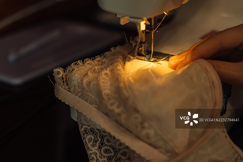 缝纫机上缝制蕾丝内衣的特写镜头图片素材