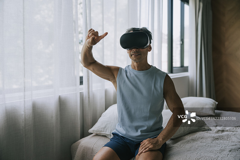 在家中使用虚拟现实头盔的日本老年男性图片素材