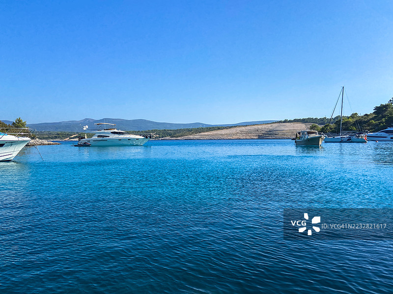 克罗地亚斯塔里格勒镇附近海岸边，各种游艇停泊在平静的蓝色海水中。图片素材