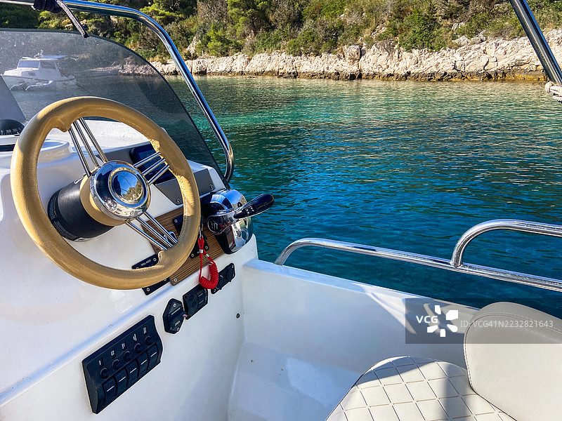 一艘小型豪华快艇的舵位，背景是绿松石色的海水。克罗地亚，赫瓦尔。图片素材